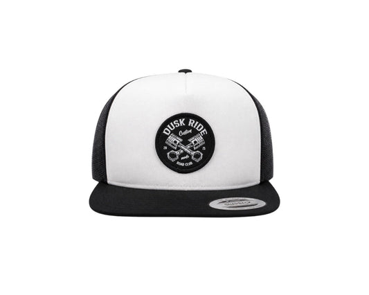 Dusk Ride Trucker Cap in Schwarz und Weiß mit rundem Pistons-Patch und Yupoong Snapback-Verschluss