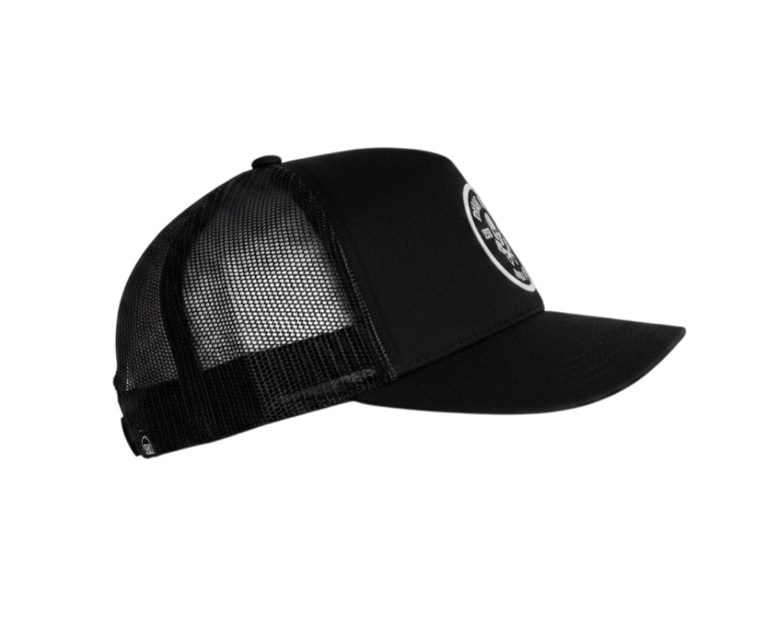 Schwarze Dusk Ride Trucker Cap mit Skull Pistons Patch und atmungsaktivem Mesh-Rückenteil in Seitenansicht