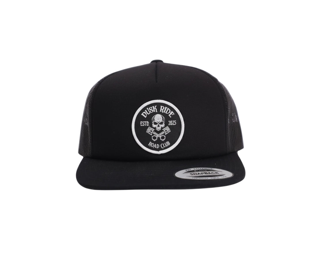 Schwarze Dusk Ride Trucker Cap mit Skull Pistons Patch und Snapback-Verschluss